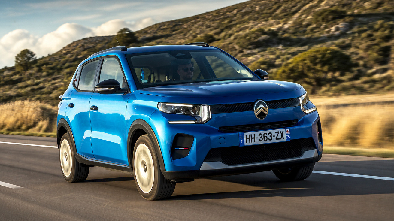 SUV Citroën azul dirigindo em estrada asfaltada com paisagem montanhosa ao fundo.