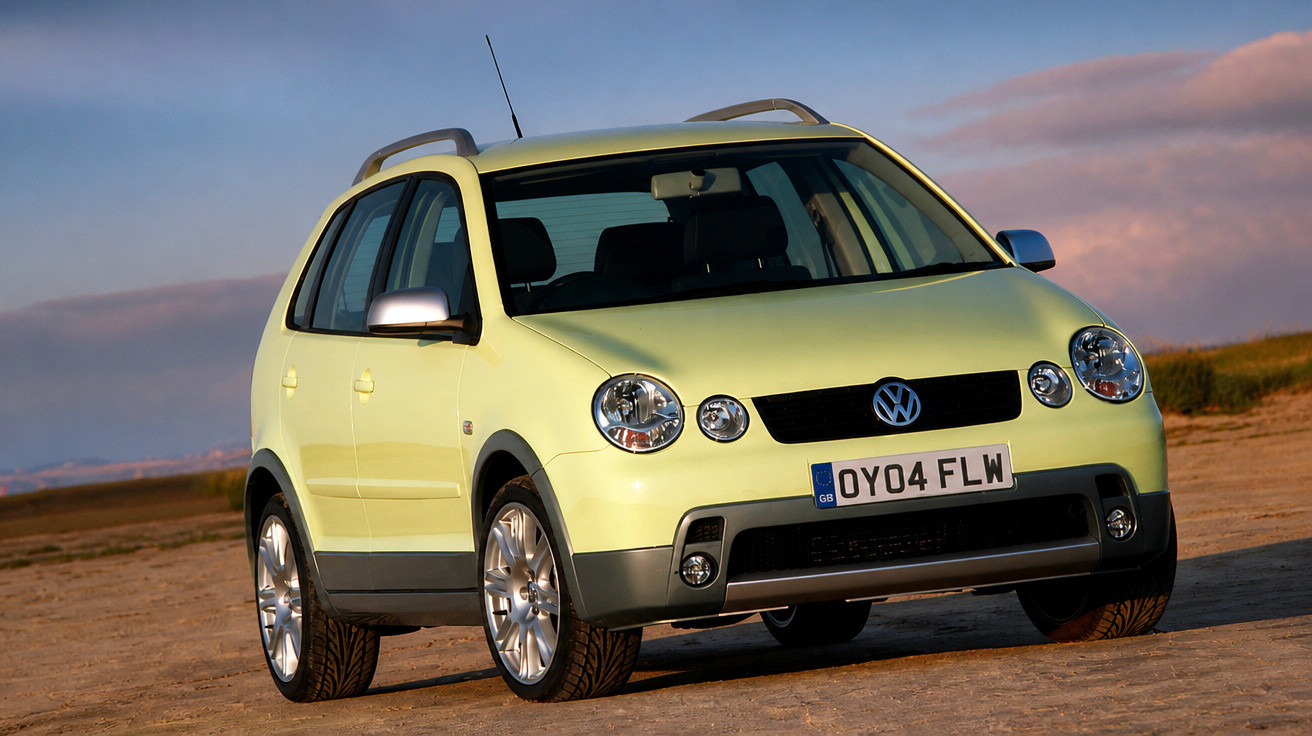 Carro Volkswagen amarelo claro estacionado em estrada de terra com céu ao entardecer.