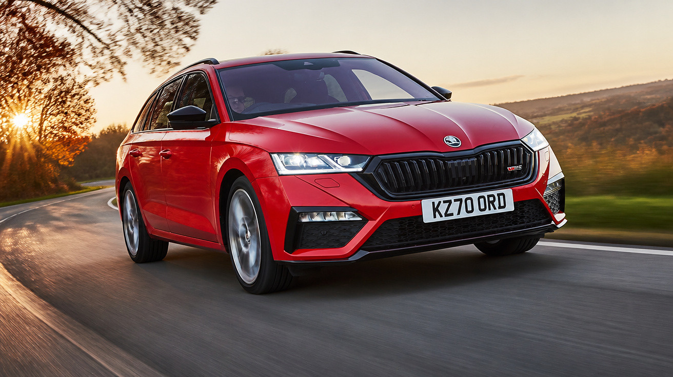 Carro esportivo vermelho em movimento em estrada sinuosa ao pôr do sol com árvores ao fundo.
