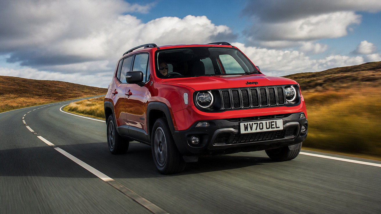 SUV Jeep Renegade vermelho dirigindo em estrada sinuosa sob céu com nuvens.