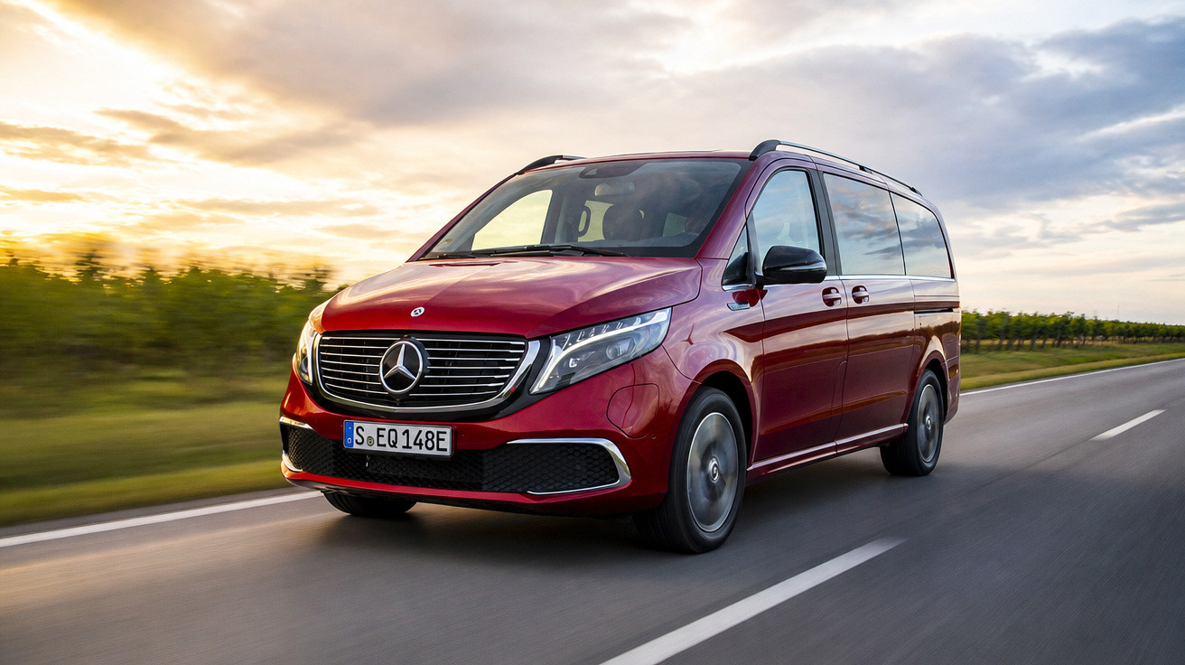 Van Mercedes-Benz vermelha em estrada asfaltada com céu nublado ao fundo, em movimento.