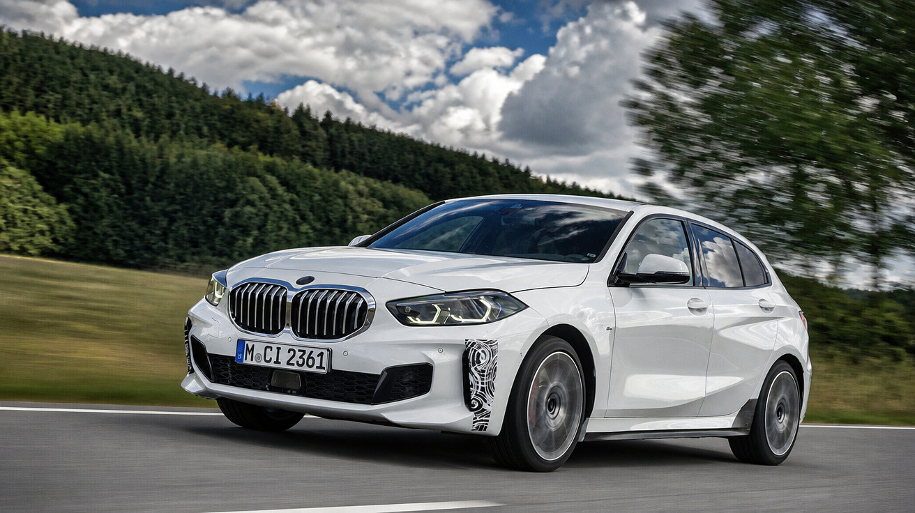 Carro branco BMW hatchback modelo esportivo em movimento em estrada rodeada por árvores e céu nublado.