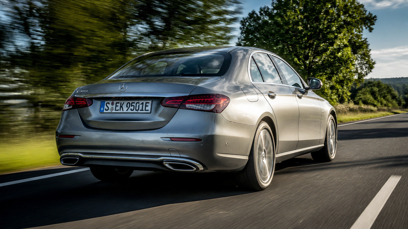 Carro sedan cinza Mercedes-Benz E 350 4MATIC em movimento em estrada asfaltada com árvores ao fundo