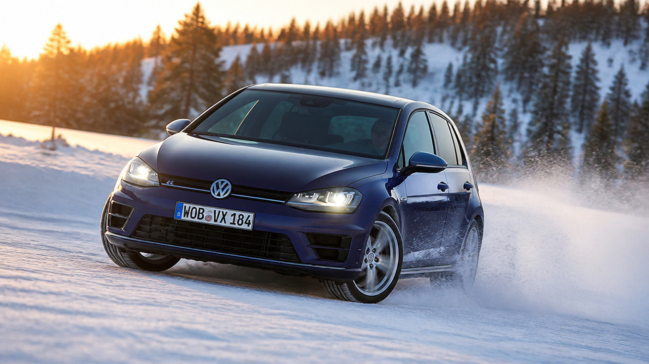 Carro Volkswagen azul escuro dirigindo em alta velocidade sobre neve com árvores ao fundo ao pôr do sol.