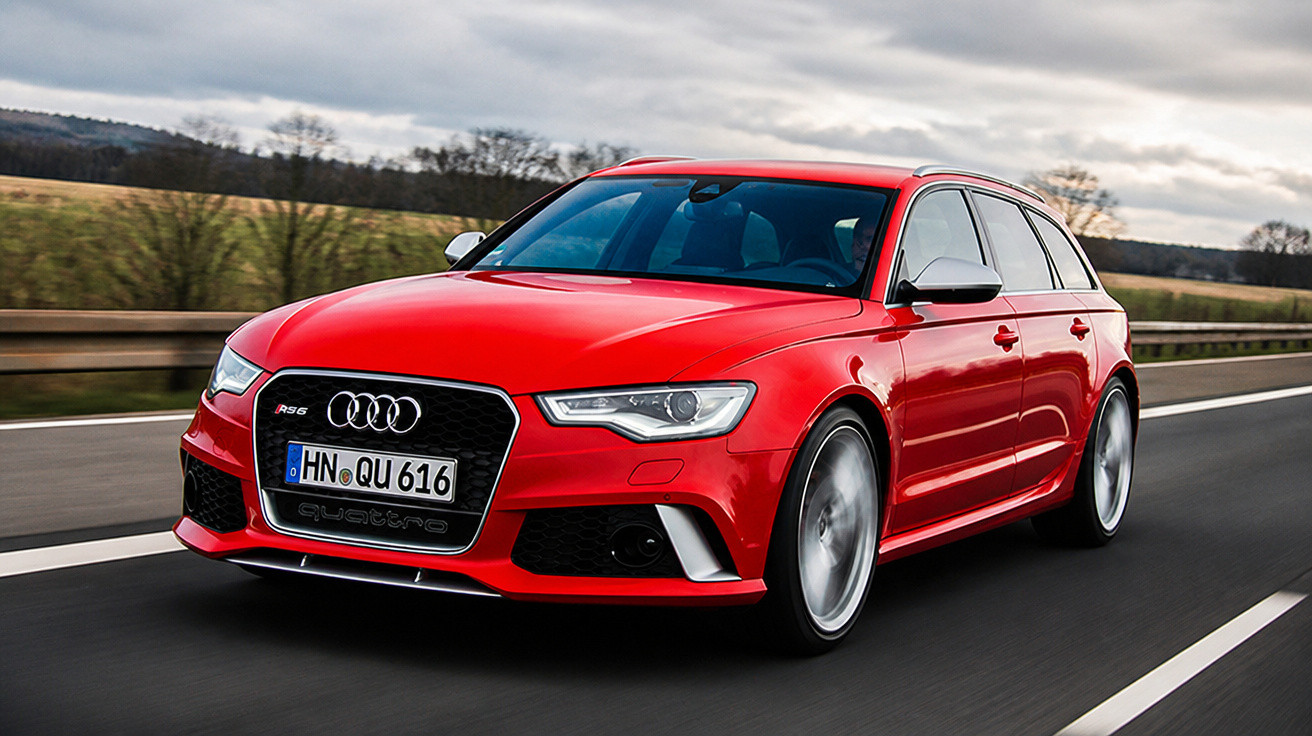 Carro esportivo Audi RS6 vermelho em alta velocidade em estrada asfaltada com céu nublado.