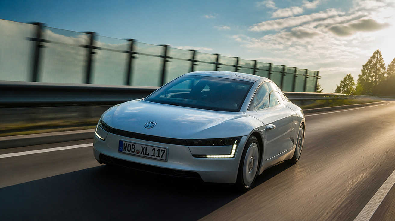 Carro elétrico Volkswagen futurista prata dirigindo em estrada com céu nublado ao entardecer.