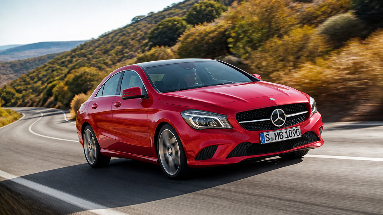 Carro sedan Mercedes-Benz vermelho em alta velocidade em estrada sinuosa com vegetação ao redor