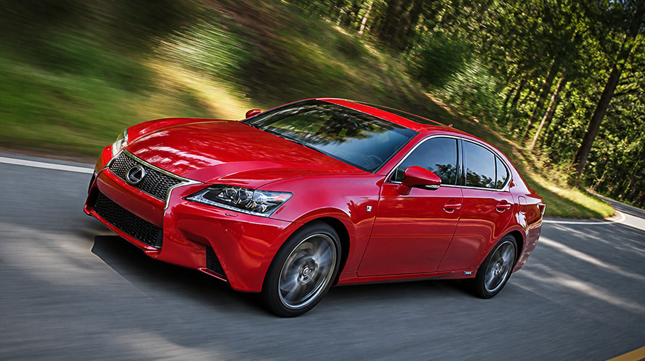 Carro vermelho esportivo Lexus em uma estrada curvada cercada por árvores.