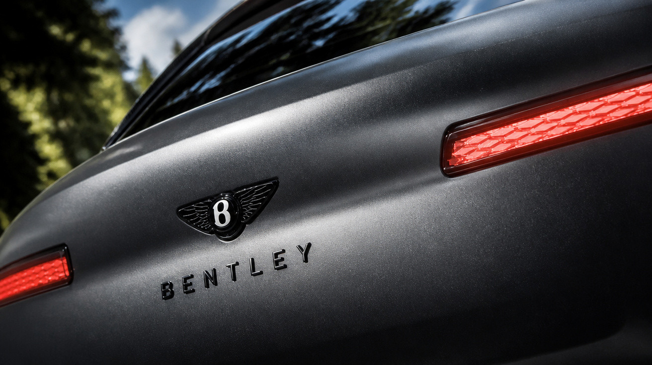 Traseira de carro Bentley preto fosco com logo e luzes vermelhas em destaque.