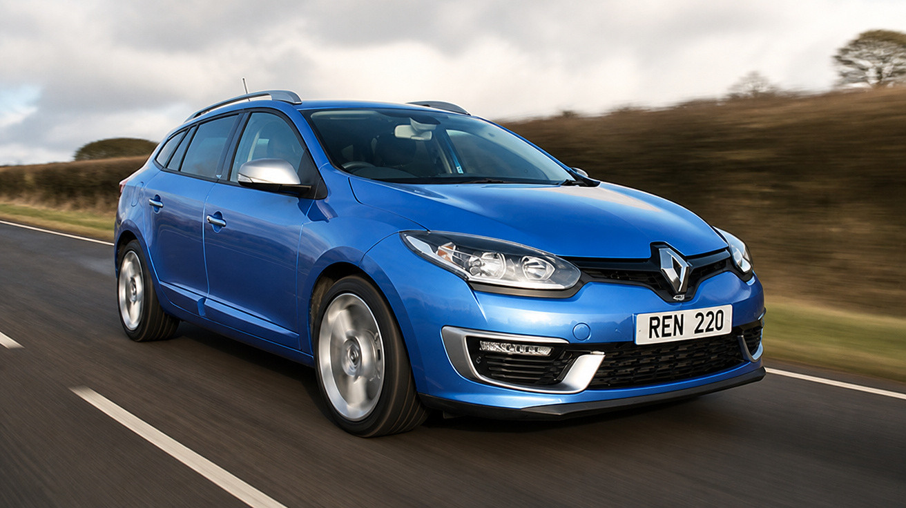Carro hatchback azul da Renault em movimento em estrada asfaltada com paisagem ao fundo.