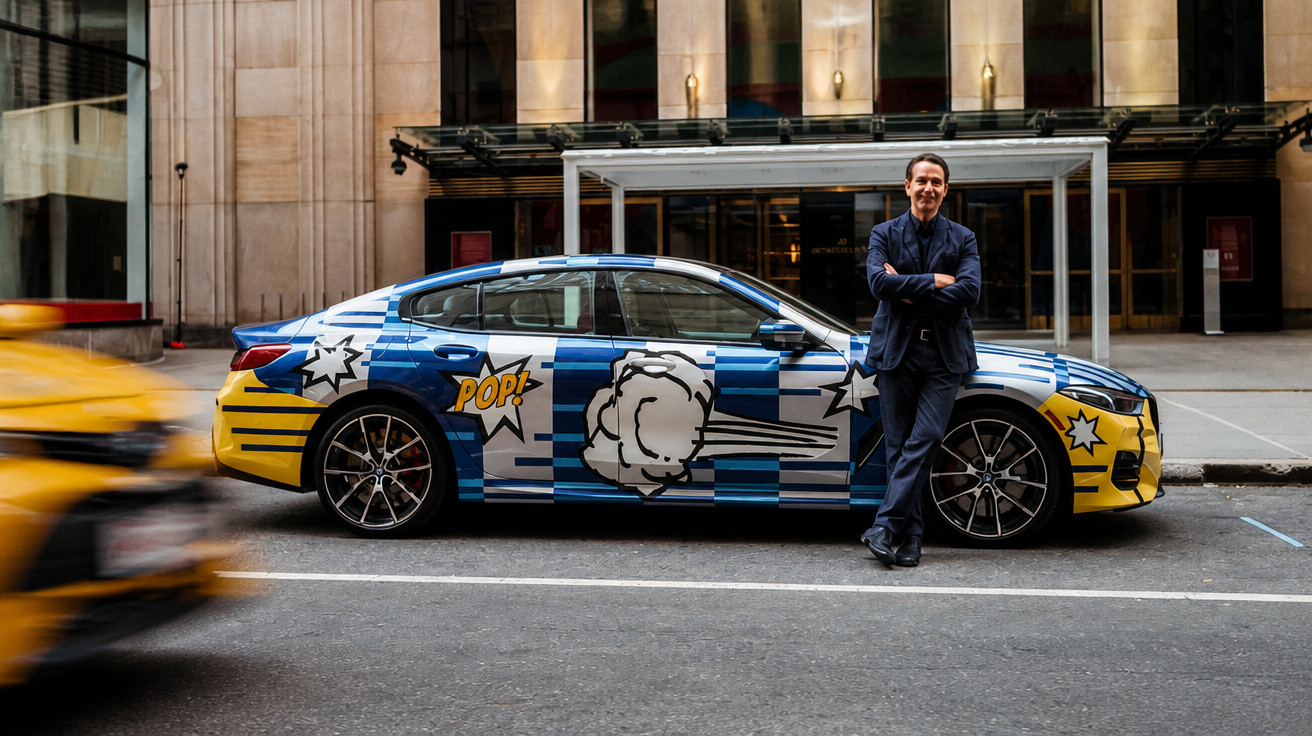 Homem encostado em carro sedan com arte pop colorida estacionado em rua da cidade.