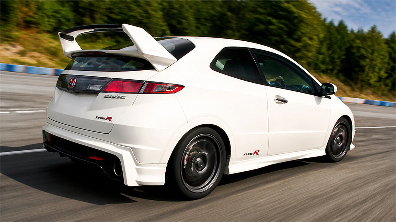 Carro esportivo branco Honda Civic Type R em alta velocidade em pista de corrida com fundo de árvores.