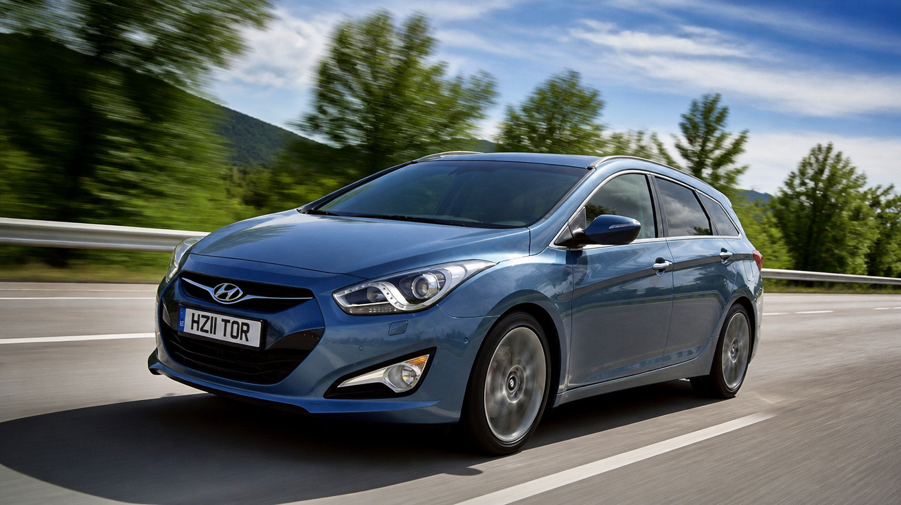Carro Hyundai azul em movimento na estrada com árvores e céu ao fundo.
