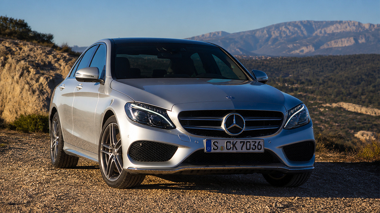 Mercedes-Benz cinza estacionado em estrada de terra com montanhas ao fundo em dia ensolarado.