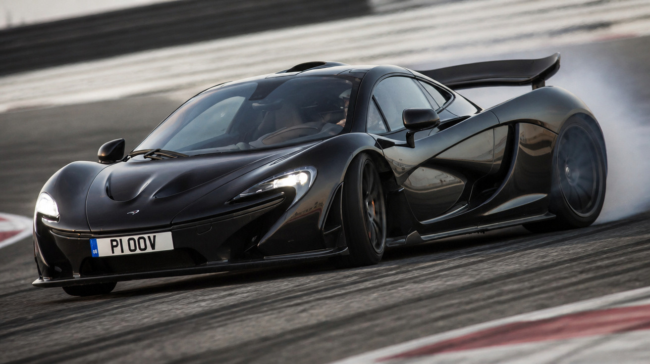 Carro esportivo preto em alta velocidade fazendo curva em pista de corrida com fumaça nos pneus.